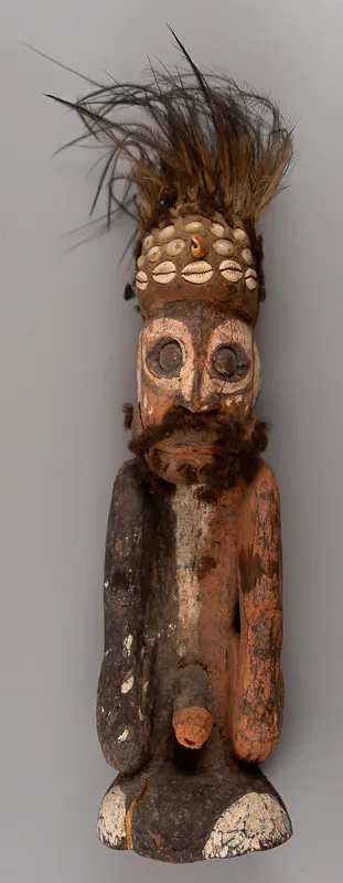 Short carved human figure with feathered headwear.