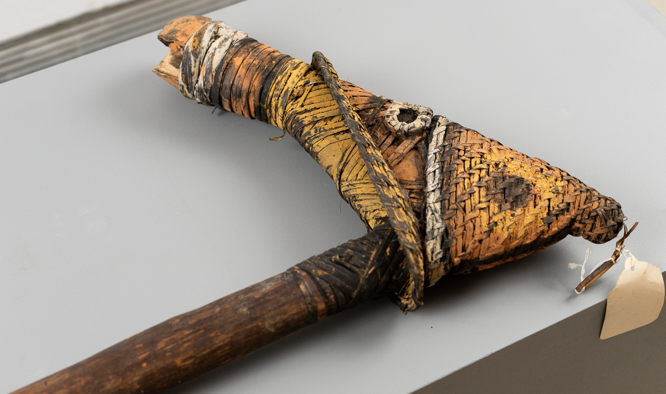 Axe made with rattan and wood with geometric markings.