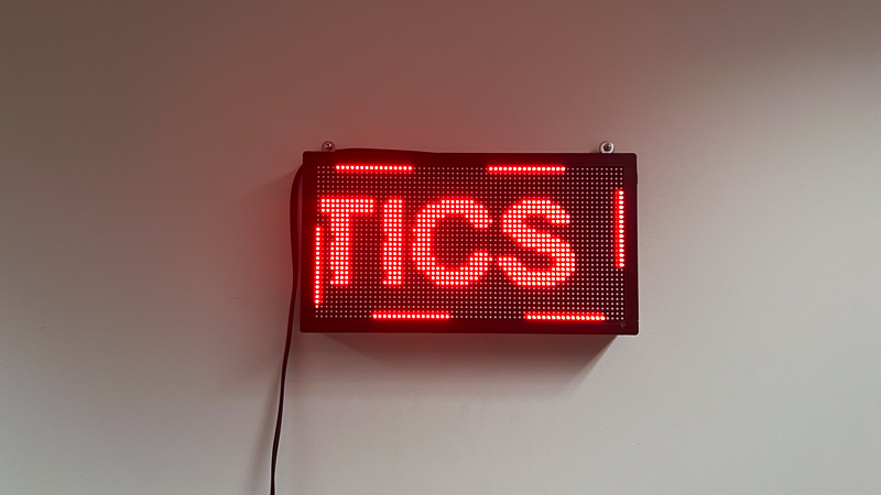 A red LED sign that reads 'Politics' in a continuous loop.