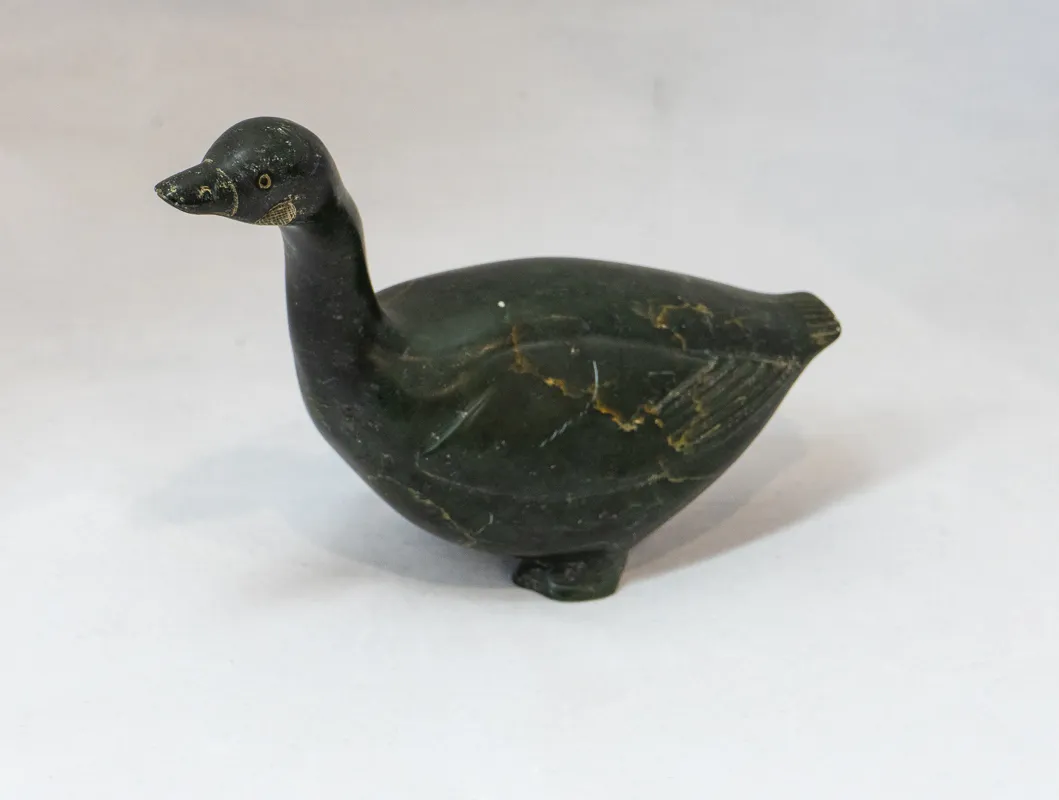 Long necked bird carved in dark stone.