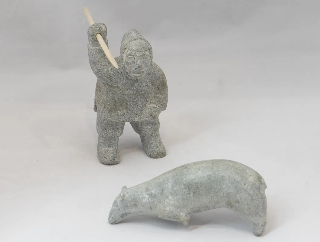 Man spearing bear in light grey stone.