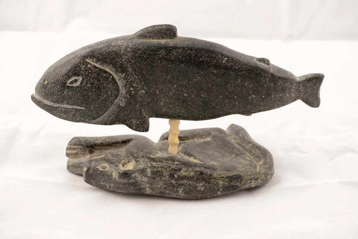 Carved Fish floating above reclining dog.