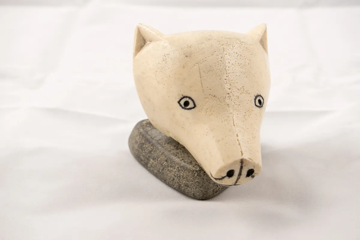 Head opf dog in bone on a small stone base. 