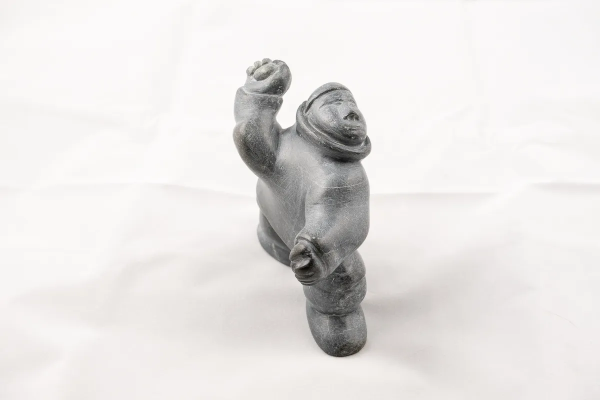Man throwing a rock carved in dark stone.