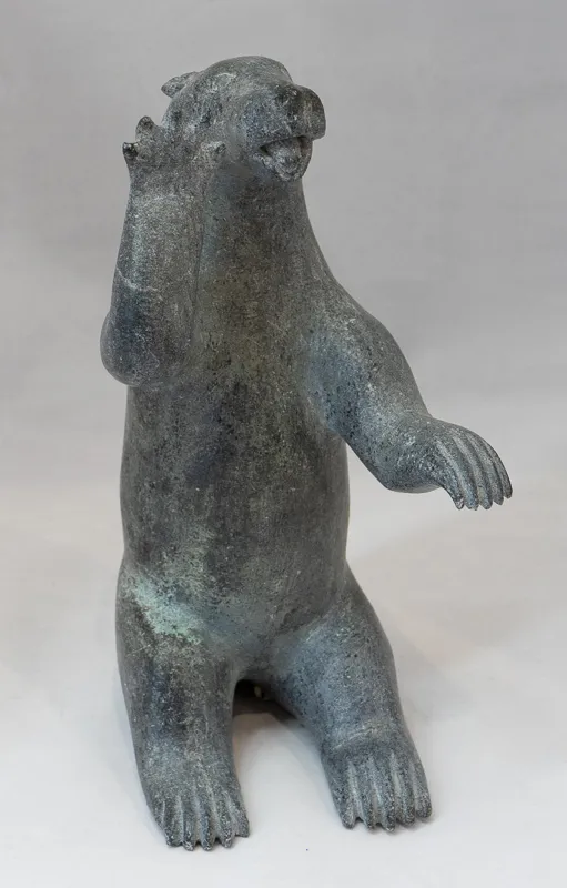 Bear posing with arm held up.