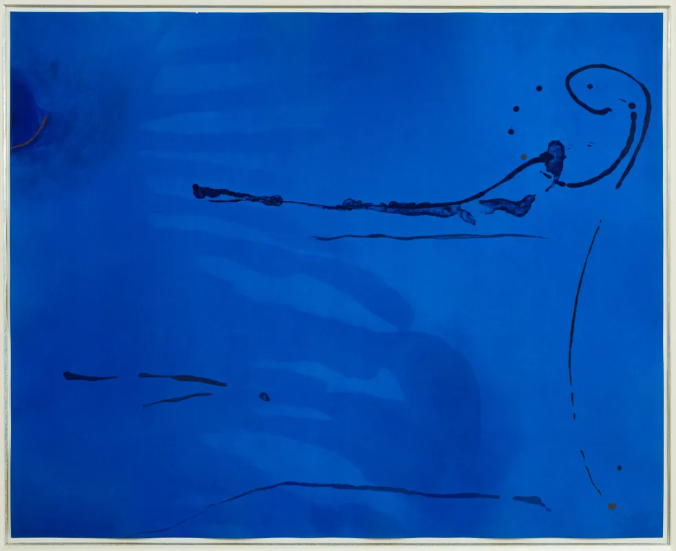 Blue stained canvas with darker blue paint dribbled on surface.