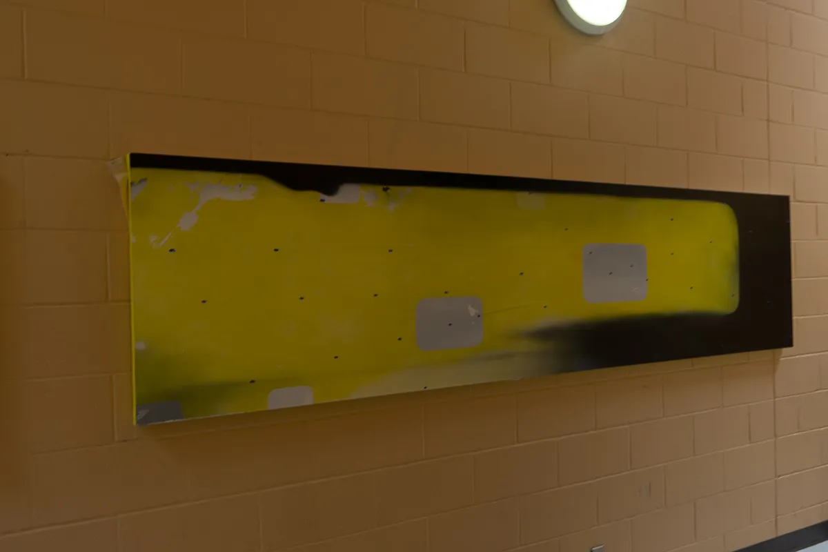 Long abstract painting, primarily yellow and black.
