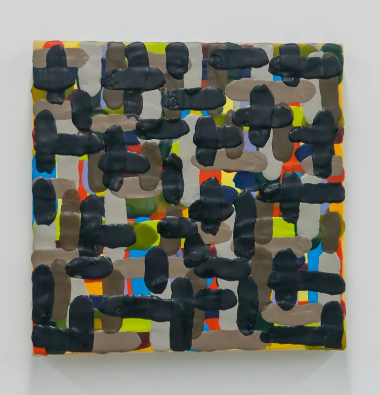 Checkerboard pattern with primarily black shapes although a few yellow, red, blue, green, and puce squares also appear.