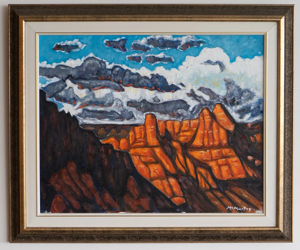 Storm cloudds above an orange cliff face. 