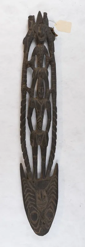 Shield-like carving with two human figures.