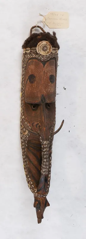 Carved wooden mask with shell decorations.