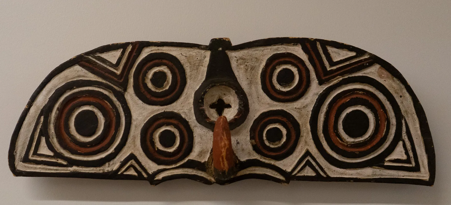 Carved wood with decorative eyes.