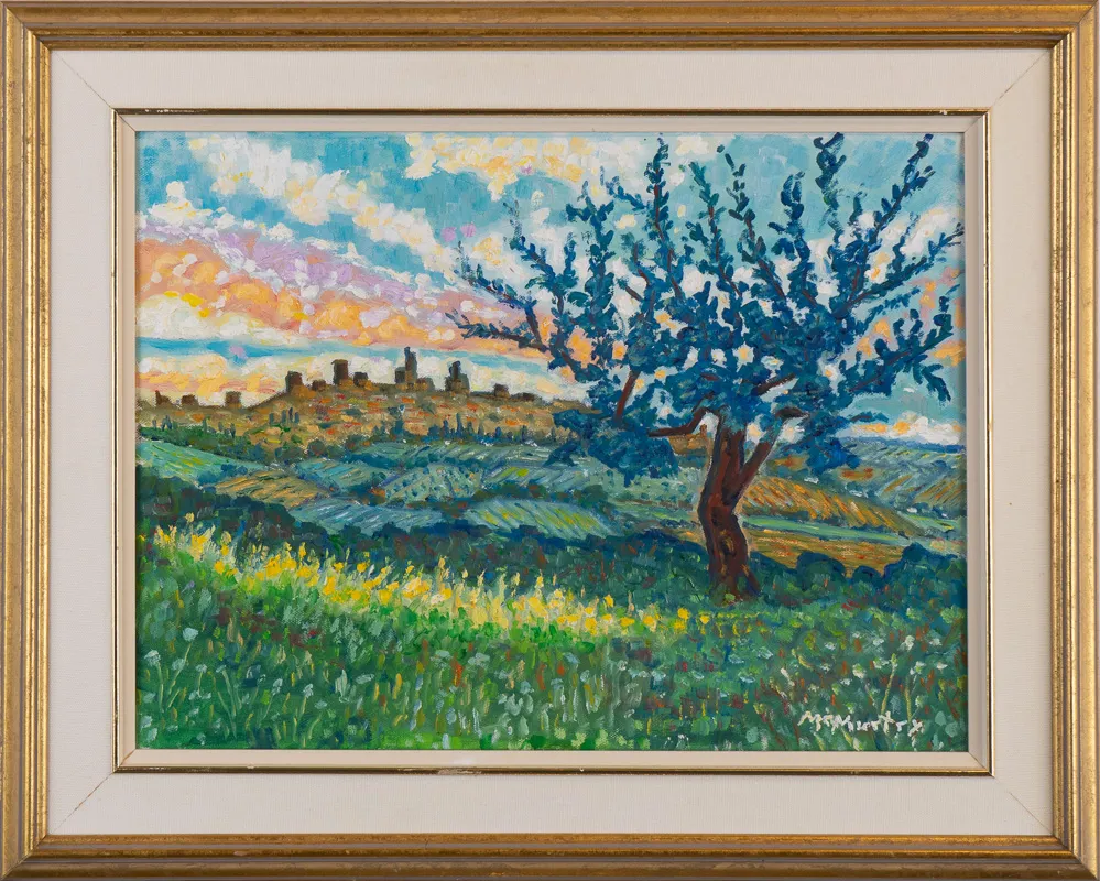 Italian countryside scene with a tree with blue leaves in the foreground.