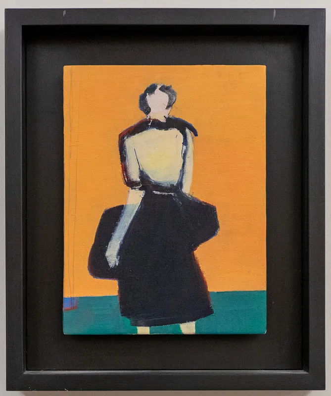Woman in a black skirt against an orange wall.