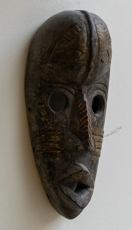 Mask in dark wood with heavily patinaed copper accents.