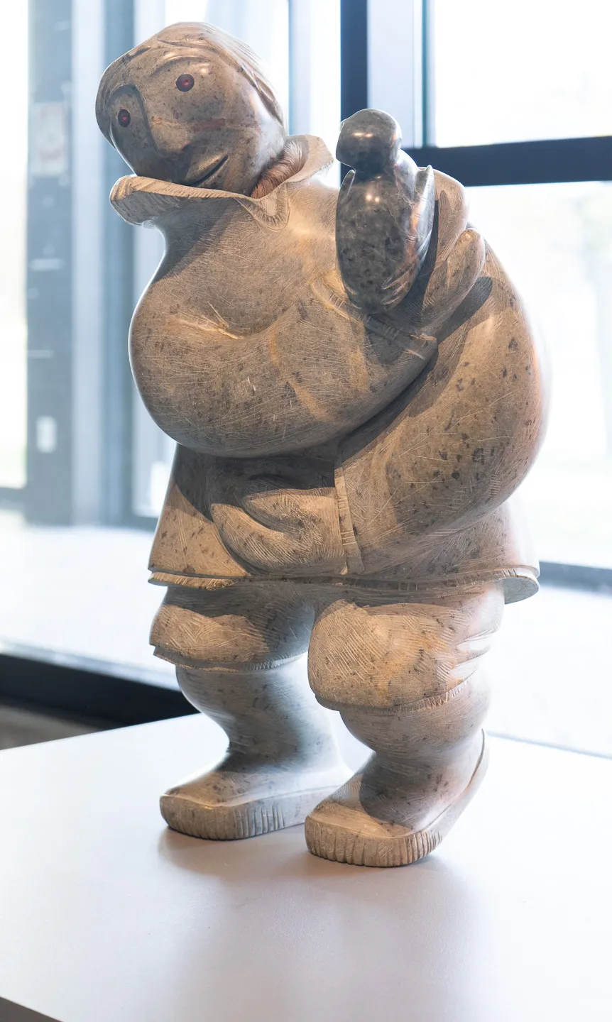Figure holding bird in one hand.