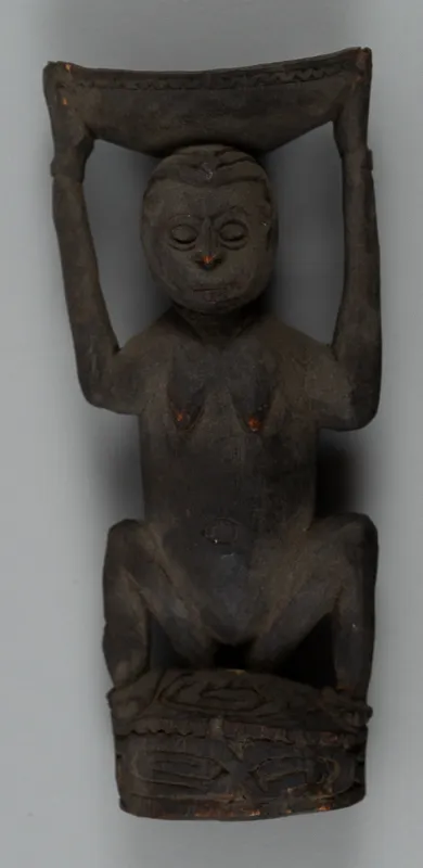 Small wooden carving in dark wood.