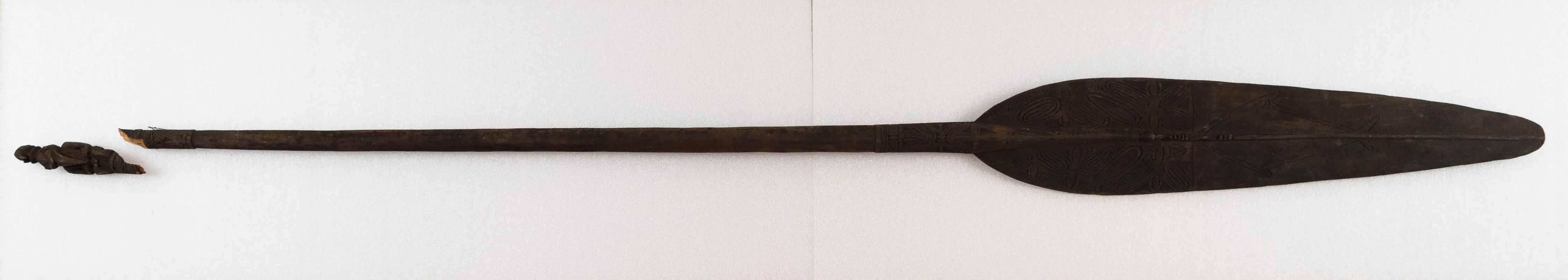 Long thin paddle with decorative carving and fine finials.