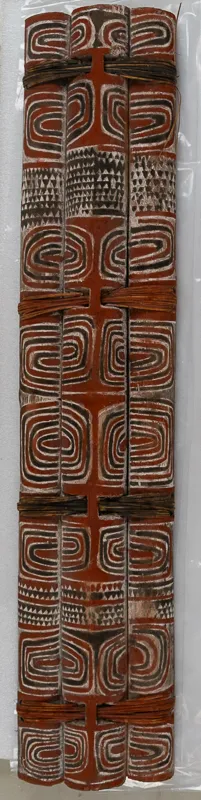Three decorated split logs fastened together into a shield with rattan.