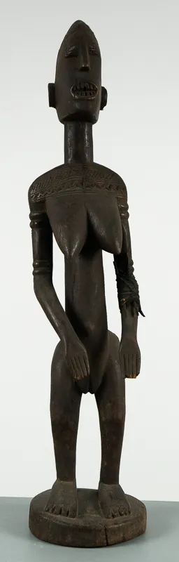Standing carved figure in dark wood.