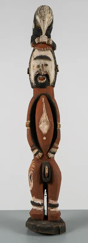 Bearded carved wood figure in red, black, and white.